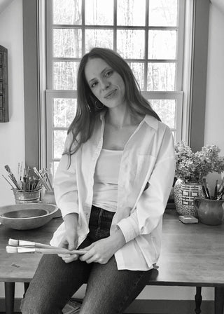 a black and white photograph of artist Sarah Grasso in her studio